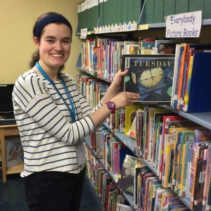 Young woman shelving books at a library
